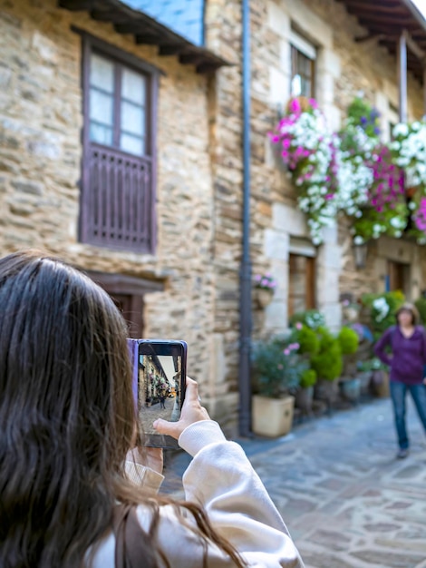 Hände, die ein intelligentes Handy verwenden und ein Foto eines Reise- und Tourismuskonzepts einer Frau machen