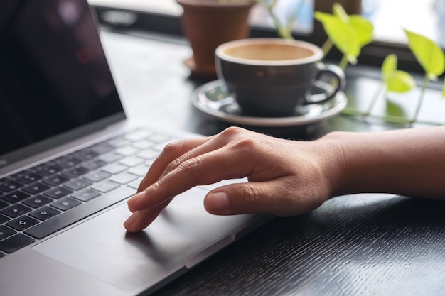 Hände, die ein Laptop-Touchpad benutzen und berühren