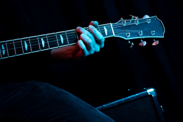 Hände, die eine Gitarre halten Machen Sie Hände beim Gitarrespielen im Aufnahmestudio Konzept des Lernens, Gitarre zu spielen