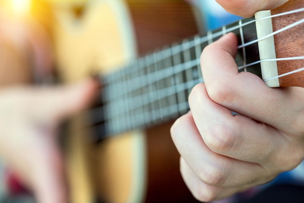 Hände, die eine Gitarrennahaufnahme spielen