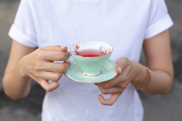 Hände, die eine Tasse Tee zum Trinken halten