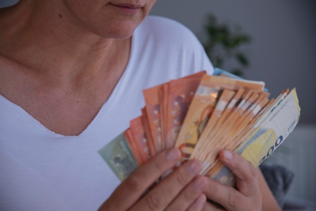Hände, die Euro in Bargeld halten, Euro in den Händen einer jungen kaukasischen Frau, Nahaufnahme