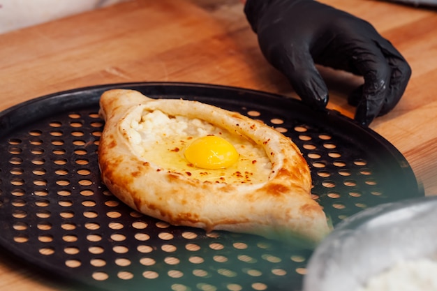 Hände, die Khachapuri in einem Café vorbereiten