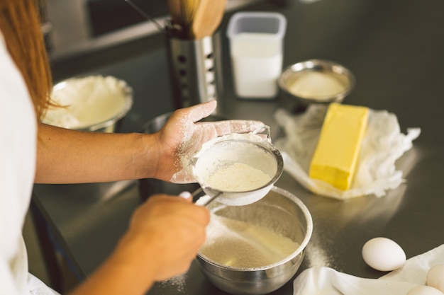 Hände, die mit Teigvorbereitungsrezept Brotpizza oder Torte arbeiten, die Zutaten backen, die Kuchen kochen