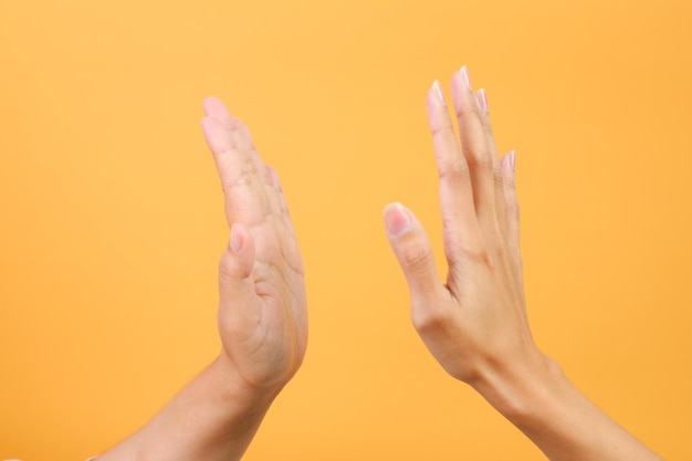 Hände, die sich gegenseitig Highfive geben, isoliert auf gelbem Hintergrund