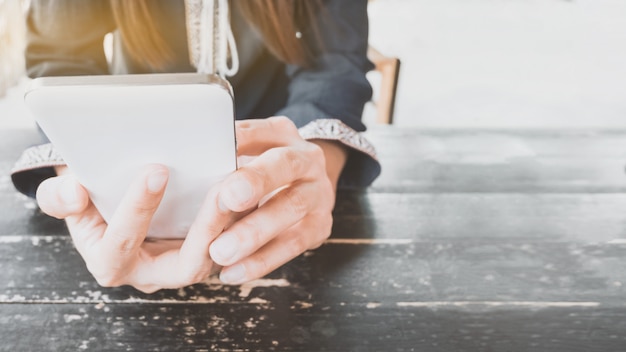 Hände, die Smartphone im Café halten.