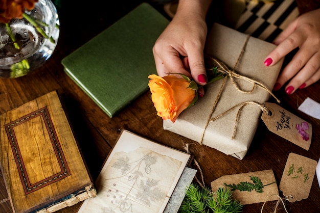 Hände diy, die Geschenkbox auf Holztisch einwickeln