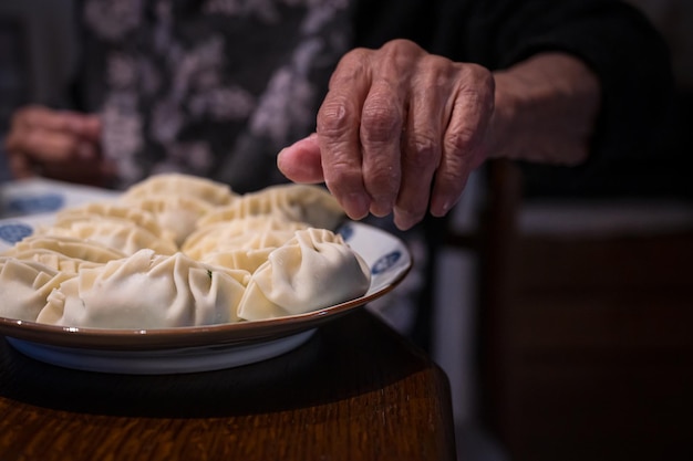 Hände einer älteren Frau, die Knödel macht