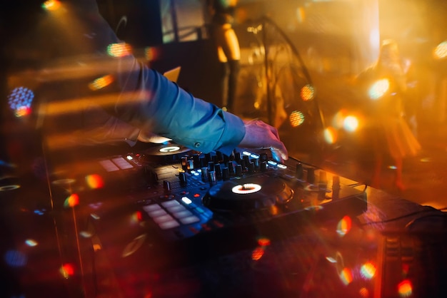 Hände eines DJ in einem Stand, der auf dem Mischer spielt