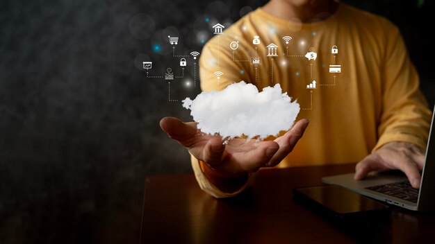 Hände eines Geschäftsmannes, der ein Smartphone-Tablet mit Cloud-Computing-Computersystemressourcen und Speicher-Cloud-Service-Technologiekonzept verwendet. Hand berührt Cloud-Computing-Symbole