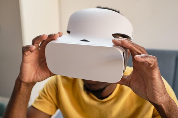 Hände eines jungen afrikanischen Mannes, der ein Virtual-Reality-Headset berührt