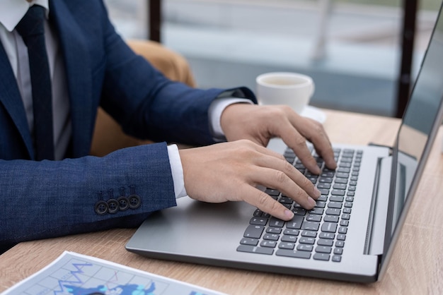 Hände eines jungen Ökonomen oder Maklers, die Tasten der Laptoptastatur berühren