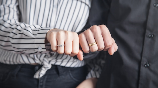 Hände eines Mannes und eines Mädchens mit Ehering.