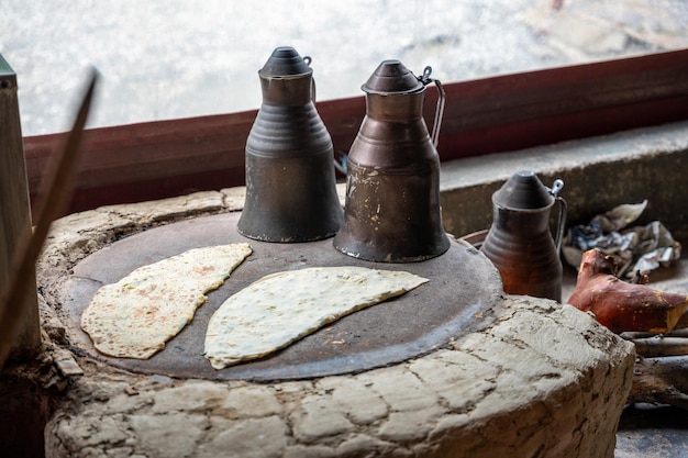 Foto hände eines türkischen kochs bereiten kartoffel-käse-gozleme auf dem heißen herd traditionell gefüllte pfannkuchen zu