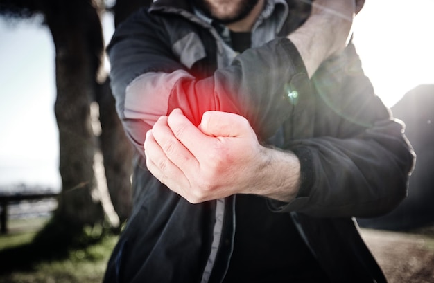 Foto hände, ellbogenschmerzen und armverletzungen nach einem sturzunfall oder fehler im freien sportfitness oder mann mit fibromyalgie, arthritis oder entzündungen, knochenbrüchen oder schmerzhaften gelenken nach dem training oder training