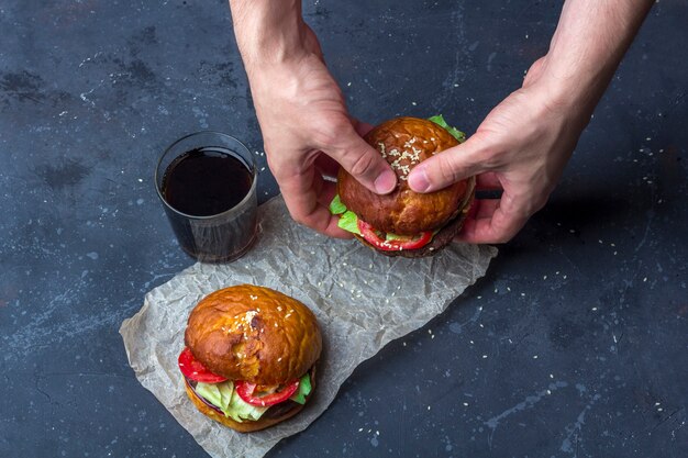 Hände frisch zubereiteten gegrillten Rindfleisch Burger