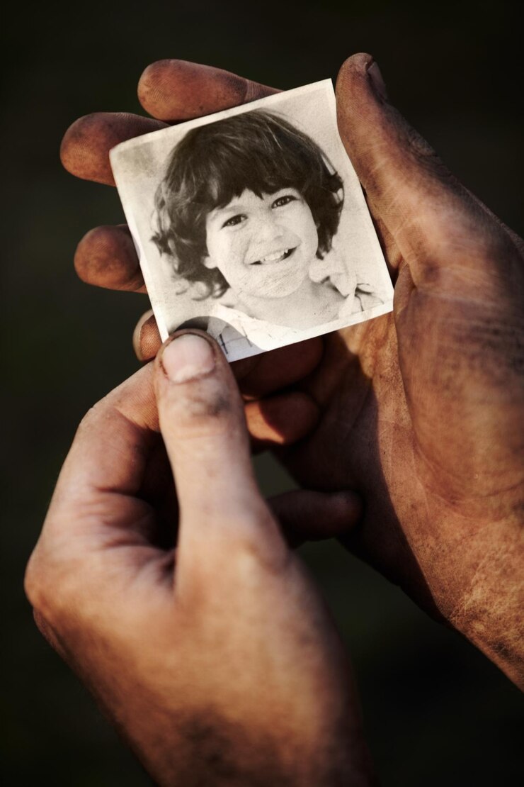 Foto hände halten bild von kind und porträt nostalgie oder erinnern erinnerung an familie oder kind isoliert auf schwarzem hintergrund im studio closeup foto von jungen und schmutzigen fingern von obdachlosen in armut