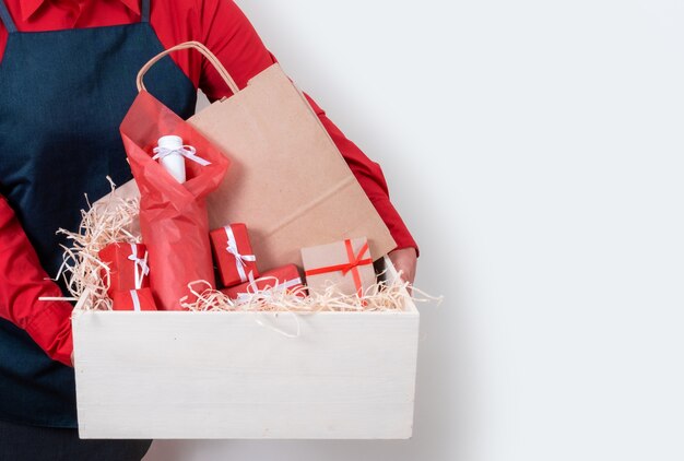 Hände halten Geschenke, Packtasche und Flasche Wein