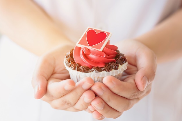 Hände halten Valentinstag Cupcake