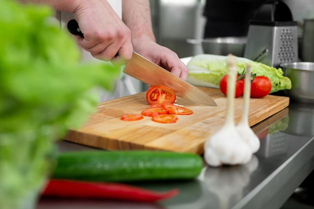 Hände in der Küche schneiden frisches Gemüse für einen Salat