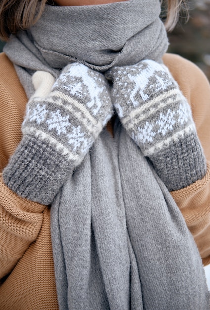 Hände in gestrickten Handschuhen. Winterlebensstil. Tragen Sie stilvolle warme Kleidung. Frau in warmen Kleidern