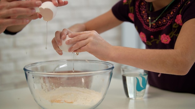 Hände kochen, Eier zerschlagen, gemeinsam Frühstück zubereiten. Mutter und Kind kochen