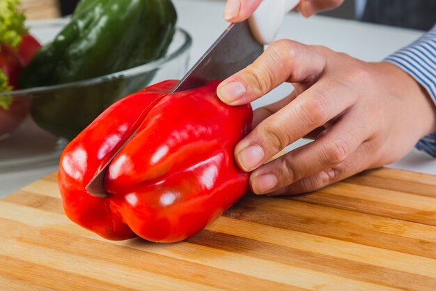 Hände mit einem Messer Paprika hacken.