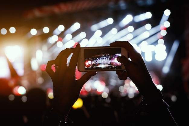 Hände mit einem Smartphone zeichnen Live-Musik-Festival auf