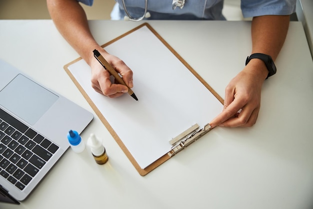 Hände mit einem Stift über einem Notizbuch