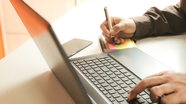 Hände mit Laptop und Smartphone