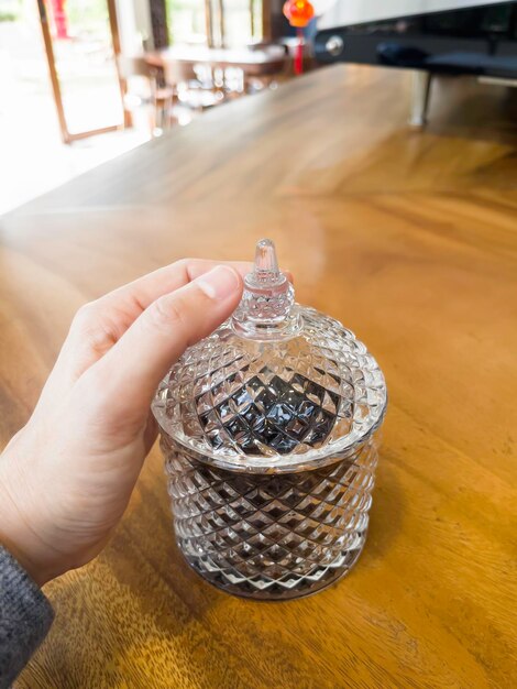 Hände öffnen ein Glas mit gerösteten Kaffeebohnen