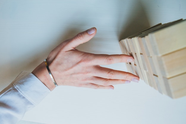 Hände spielen eine Blöcke Holz Turm Spiel (Jenga)