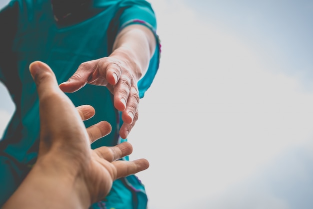 Hände strecken die Hand aus, um sich gegenseitig zu helfen