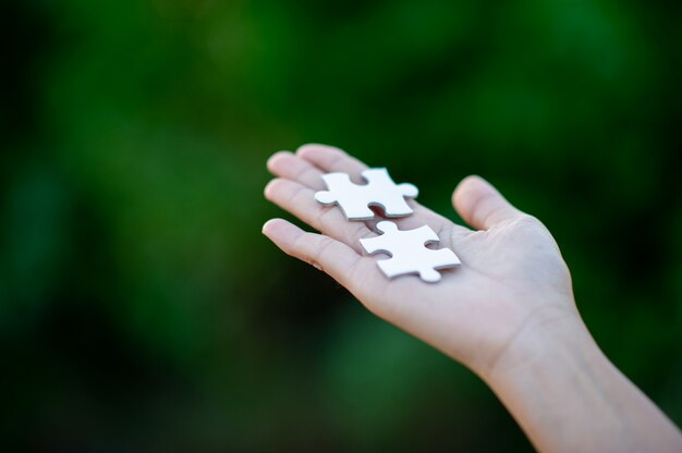 Hände und weiße Puzzlen