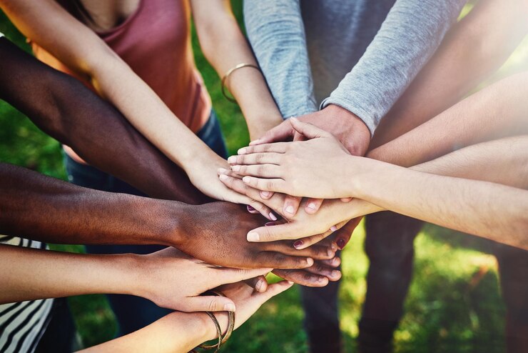 Foto hände vielfalt und freunde in einem park für teamarbeit, partnerschaft und freiwilligenmission von oben. draufsicht auf menschen und handunterstützung durch eine freiwilligengruppe im freien für wohltätigkeit und aktivismus in der gemeinschaft