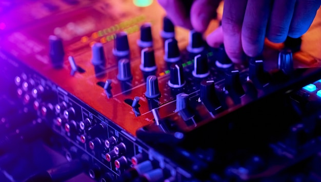 Hände von DJ-Mixing-Tracks auf professionellem Sound-Mixer. Nahaufnahme, Knöpfe und Regler im Fokus. Foto in hoher Qualität