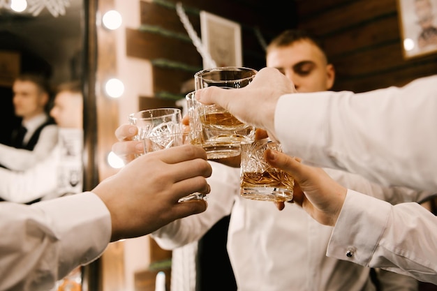 Hände von Männern mit einem Glas Spirituosen-Whisky-Cognac