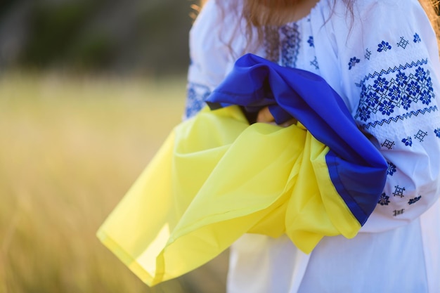 Hände von Teenager-Mädchen mit einer ukrainischen Flagge auf ihren Schultern