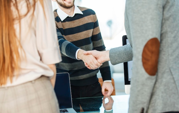 Foto händedruck zwischen dem kunden und dem manager des unternehmens in der nähe des arbeitsplatzes