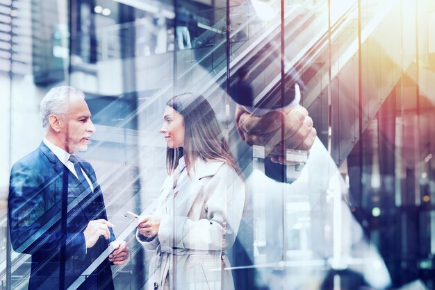 Händeschüttelnde Geschäftsperson im Bürokonzept der Teamarbeit und der Doppelbelichtung der Partnerschaft