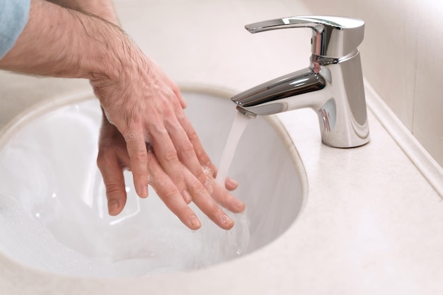 Händewaschen mit Seife und heißem Wasser im Waschbecken