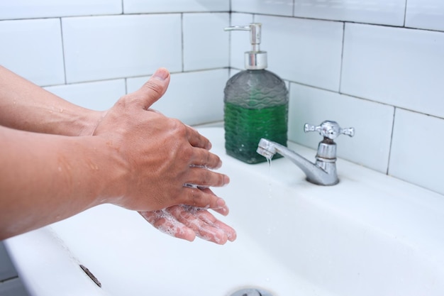 Händewaschen mit Seife unter dem Wasserhahn mit Wasser Hygienekonzept