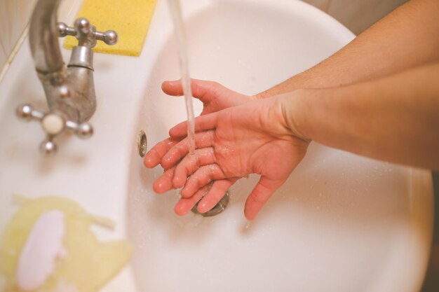 Händewaschen mit Wasser und Seife, um Coronavirus vorzubeugen Handwäsche Vintage-Fotoverarbeitung