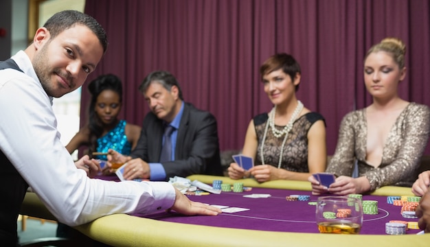 Händler, der am Pokerspiel lächelt