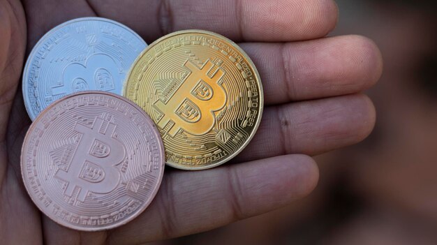 Händler, der Bitcoins-Kryptowährungsmünzen in der Hand hält