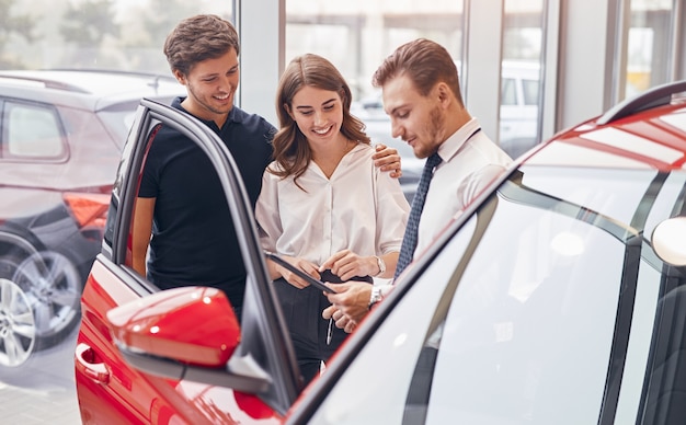 Foto händler hilft paar bei der wahl des autos