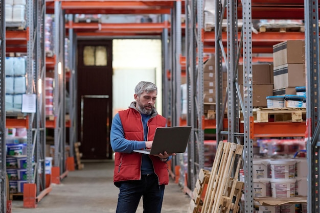 Händler mit Laptop im Lager