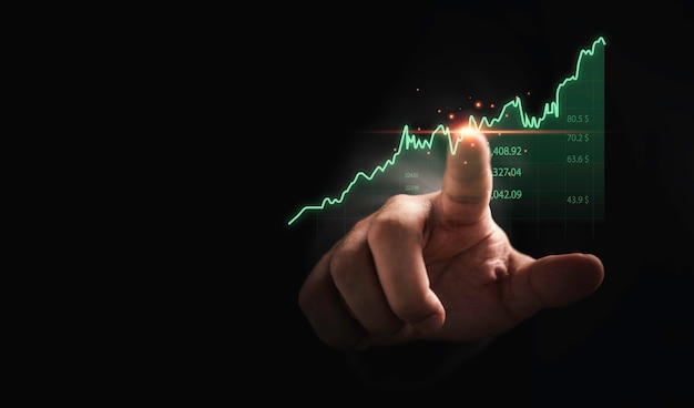 Händlerhand, die das Börsendiagramm auf dunklem Hintergrund für das Konzept der technischen Investitionsanalyse berührt.