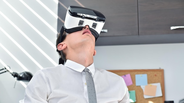 Händlermann, der im Büro mit VR-Brille aufschaut