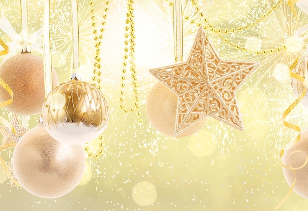 Hängende goldene Weihnachtskugeln reihen sich auf goldenem Bokeh-Hintergrund